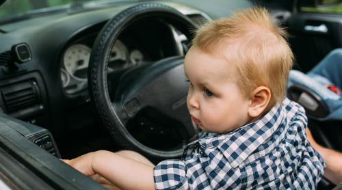 Gest inconștient: O femeie a fost prinsă scriind pe telefon, în timp ce copilul ei de un an ținea volanul