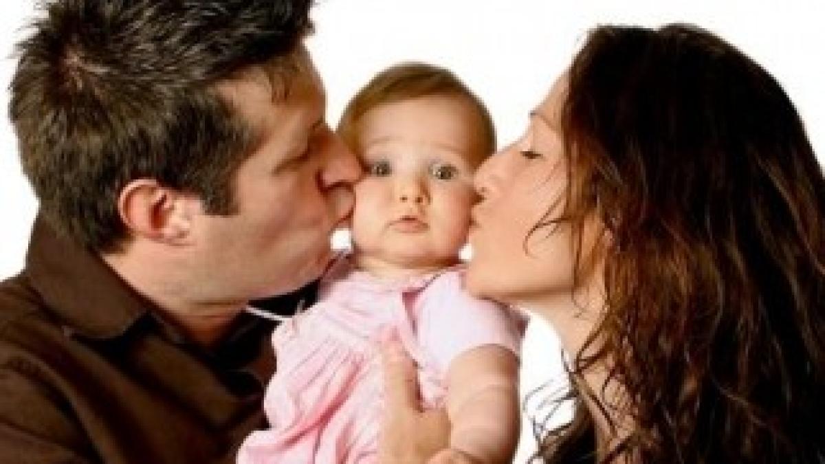 bigstock_Mom_And_Dad_Kissing_Cute_Baby__19501931Web