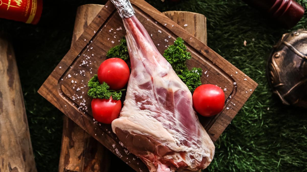 raw-lamb-leg-wooden-board-prepared-cooking-salt-tomato-greens-top-view_67463700