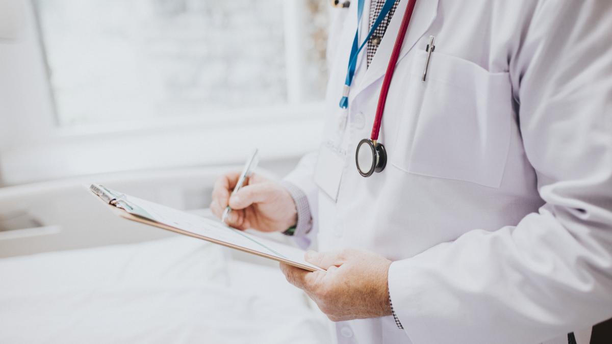 physician-noting-down-symptoms-patient_09190200