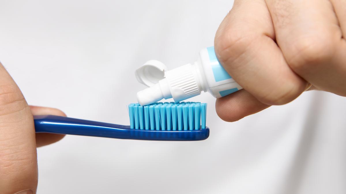 close-up-image-man-s-hands-holding-tube-squeezing-whitening-toothpaste-brush_32757300