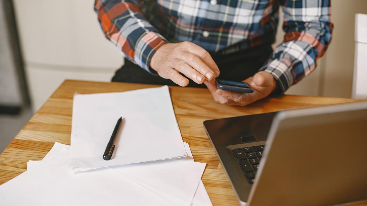 old-man-with-laptop-grandfather-sitting-christmas-decorations-man-with-mobile-phone_25751600