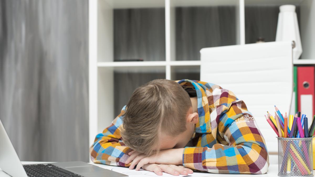 boy-sleeping-front-laptop-desk_58683700
