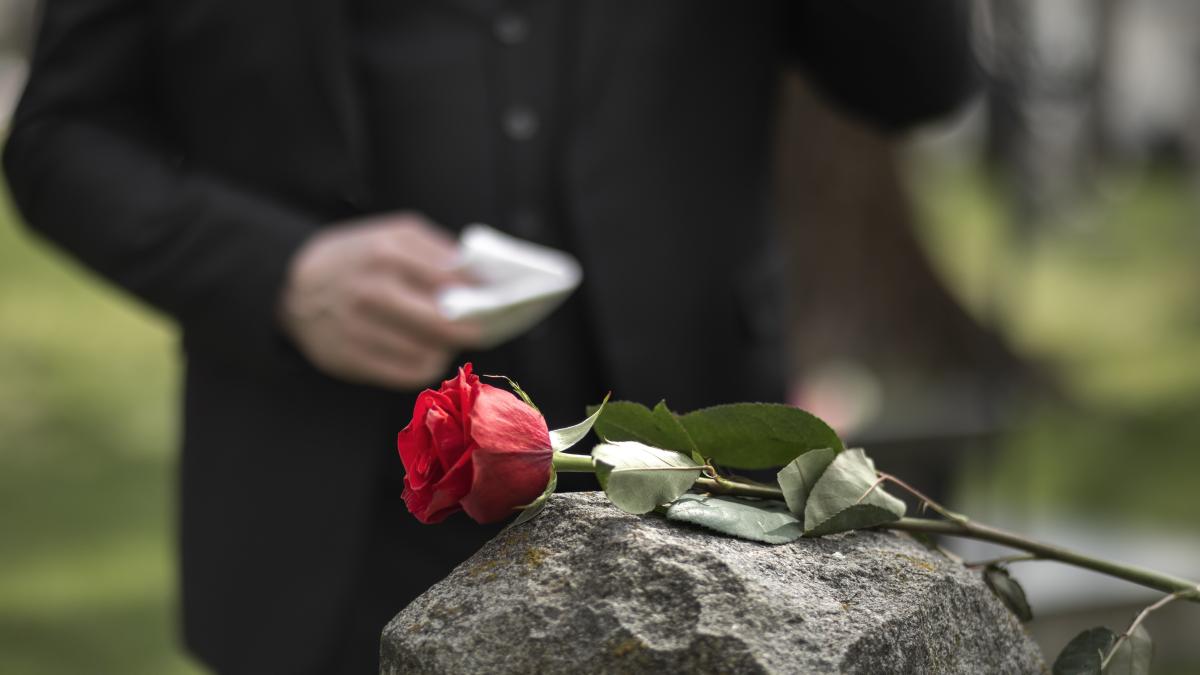man-paying-respect-tombstone-cemetery_16668500