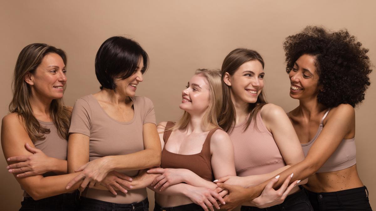 beautiful-ladies-different-ages-nations-brown-tops-look-each-other-holding-hands-beige-background_88978500