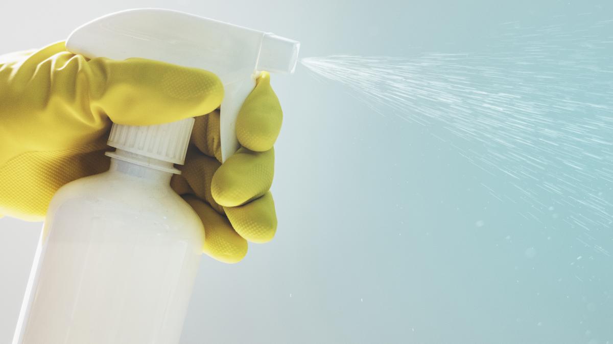 rubber-gloved-hand-holding-white-spray-bottle_83293900