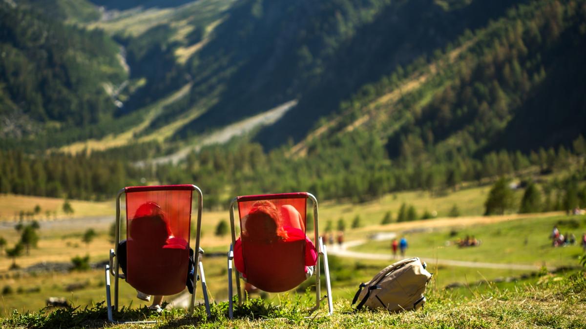 grassy-field-with-two-people-laying-chairs-enjoying-view_86774500