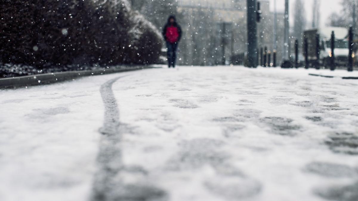 low-angle-shot-person-walking-snow-covered-sidewalk-snow_81003900