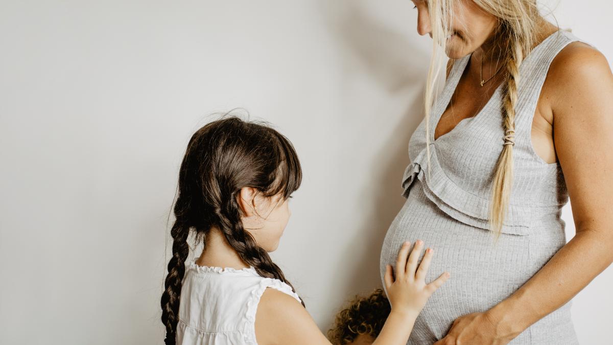girl-touching-belly-pregnant-mother_15642900