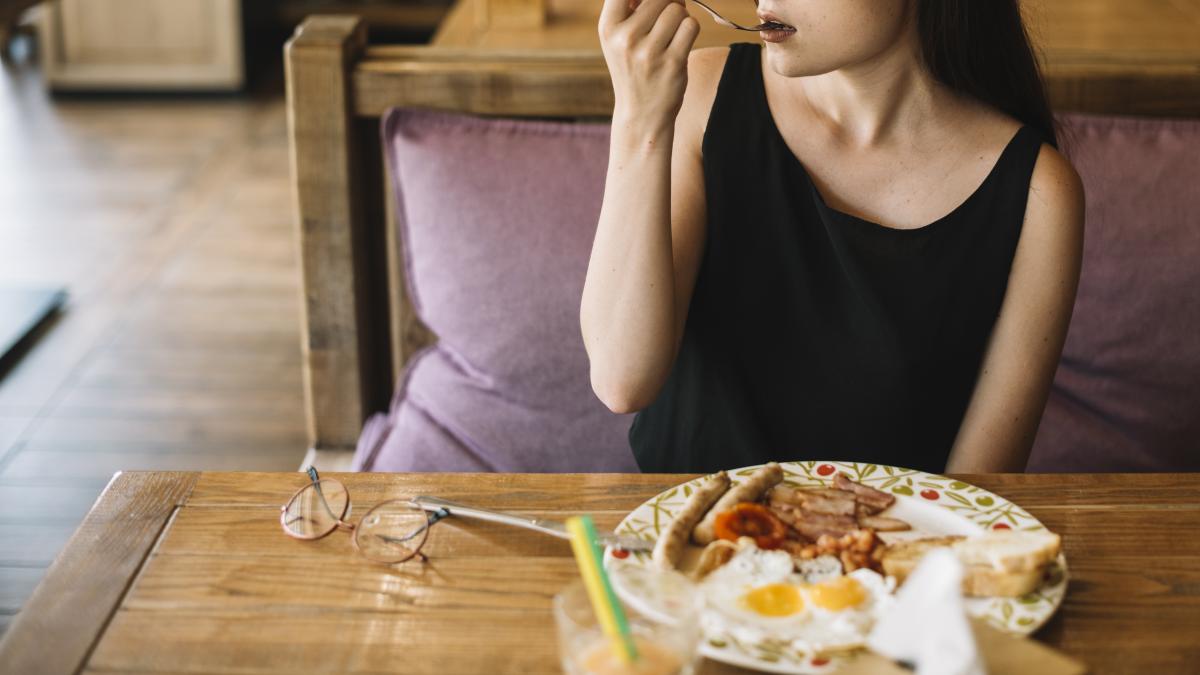 woman-eating-breakfast-restaurant_96134600