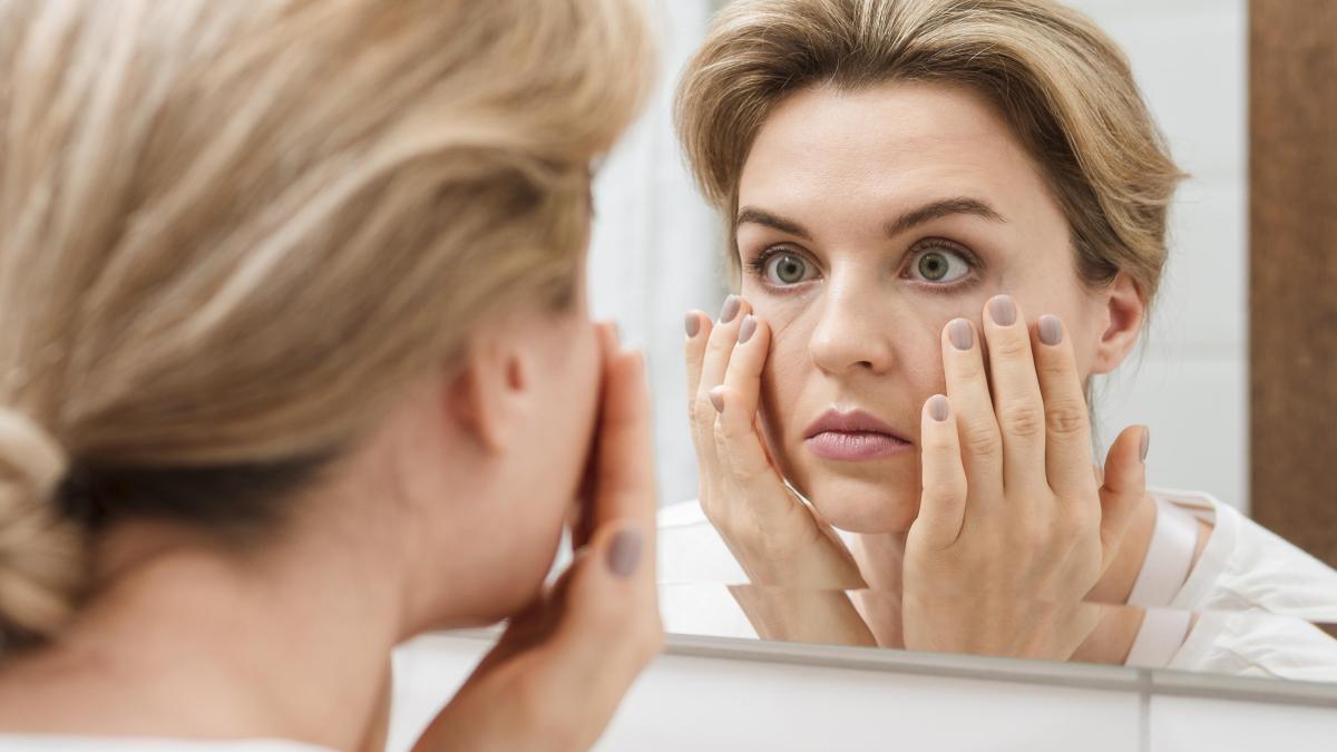 woman-checking-her-eyes-mirror_72228400