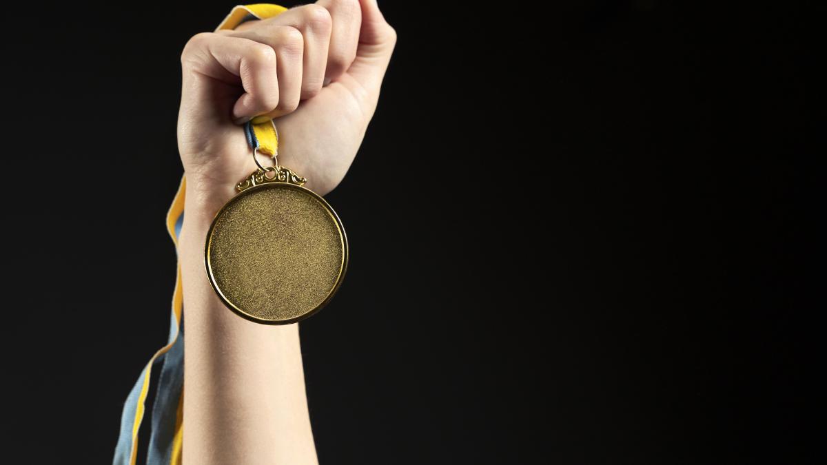 athlete-holding-gold-medal-closeup_89470400
