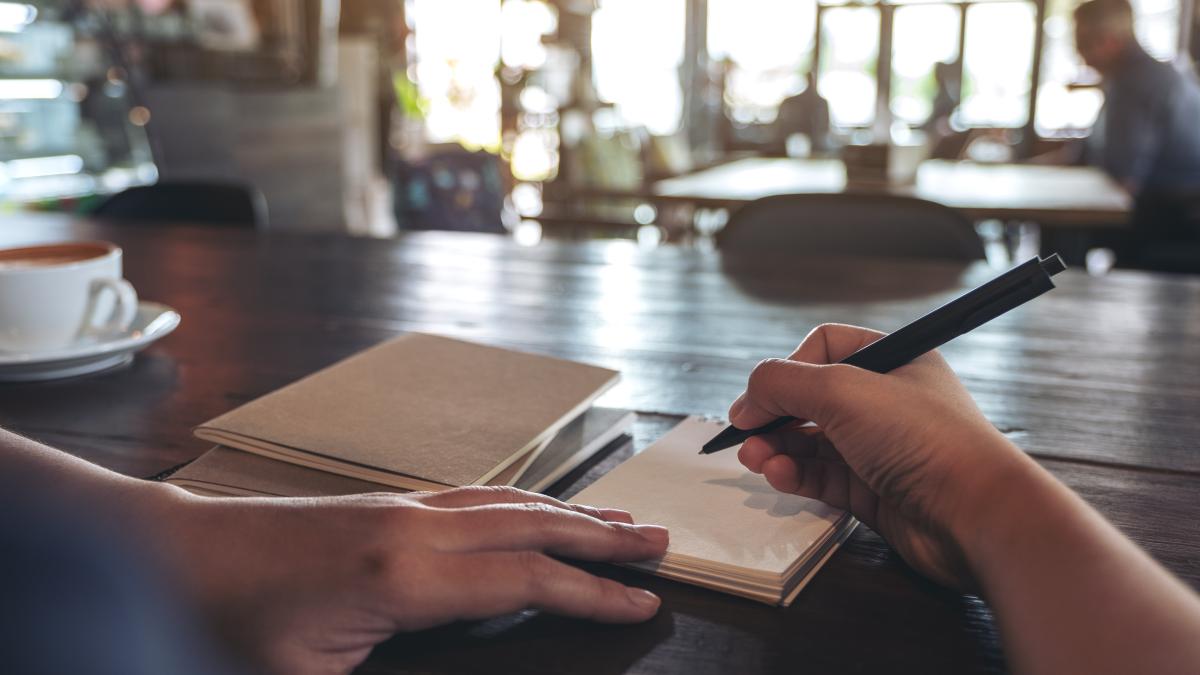 midsection-woman-reading-book-table_65349500