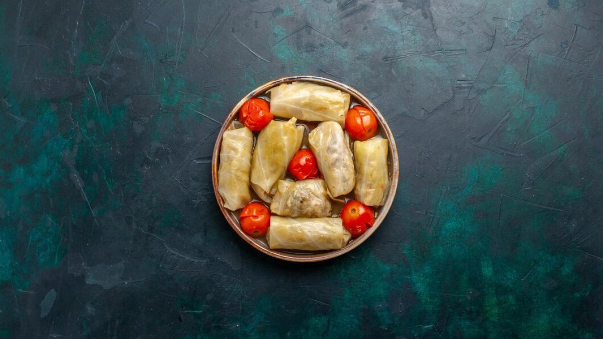 top-distant-view-delicious-meat-meal-rolled-inside-cabbage-with-tomatoes-dark-blue-desk_140725-61800_51498300