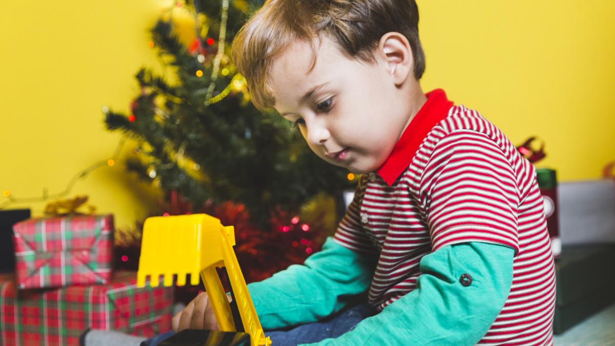 christmas-concepto-with-kid-playing-front-christmas-tree_60853900