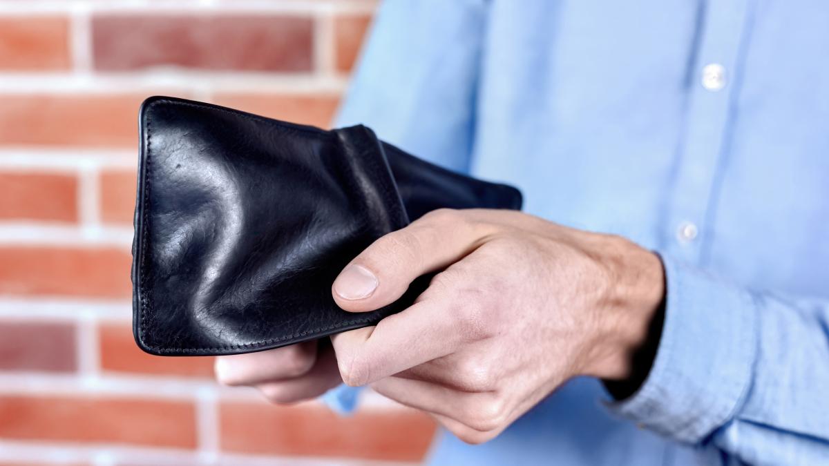 man-blue-shirt-showing-black-empty-wallet_24932700