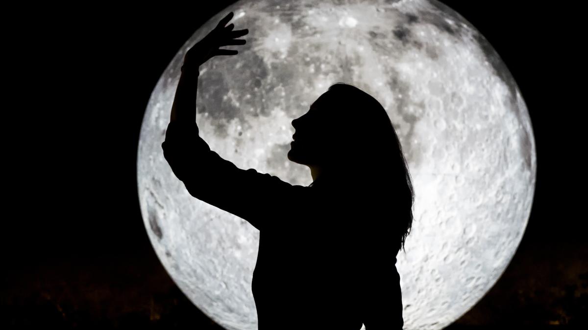 silhouette-woman-gesturing-while-standing-against-full-moon-sky-night_12489400