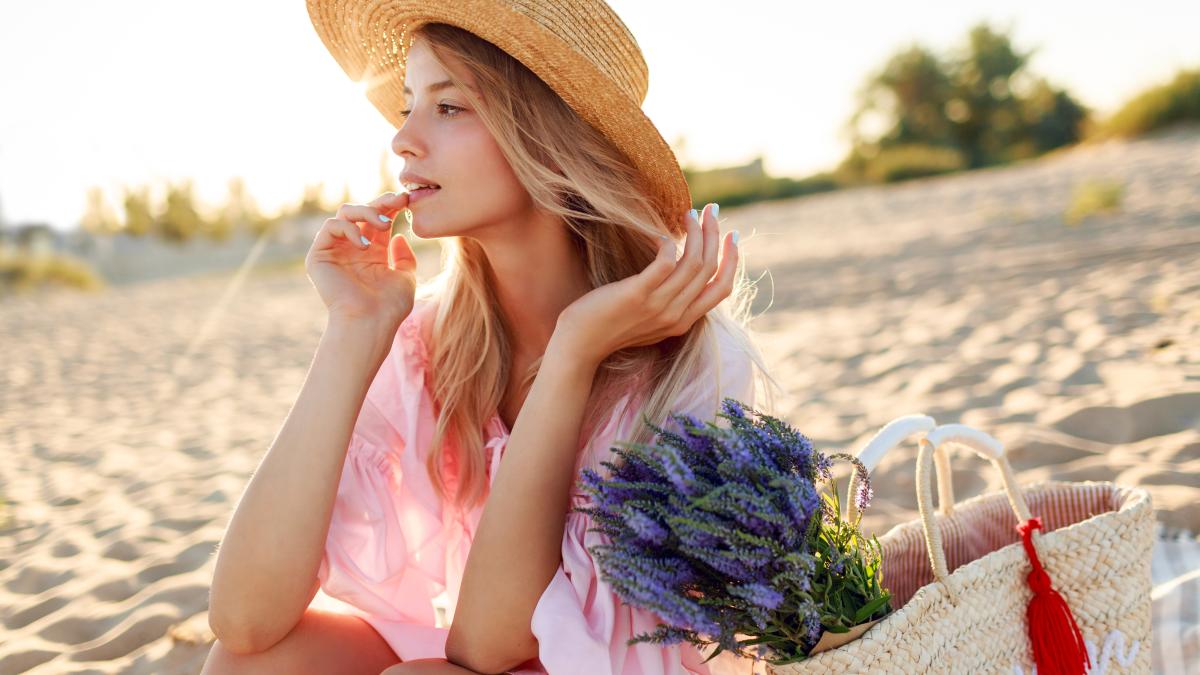 romantic-white-woman-trendy-hat-elegant-pink-dress-posing-beach-holding-straw-bag-bouquet-flowers_27091800