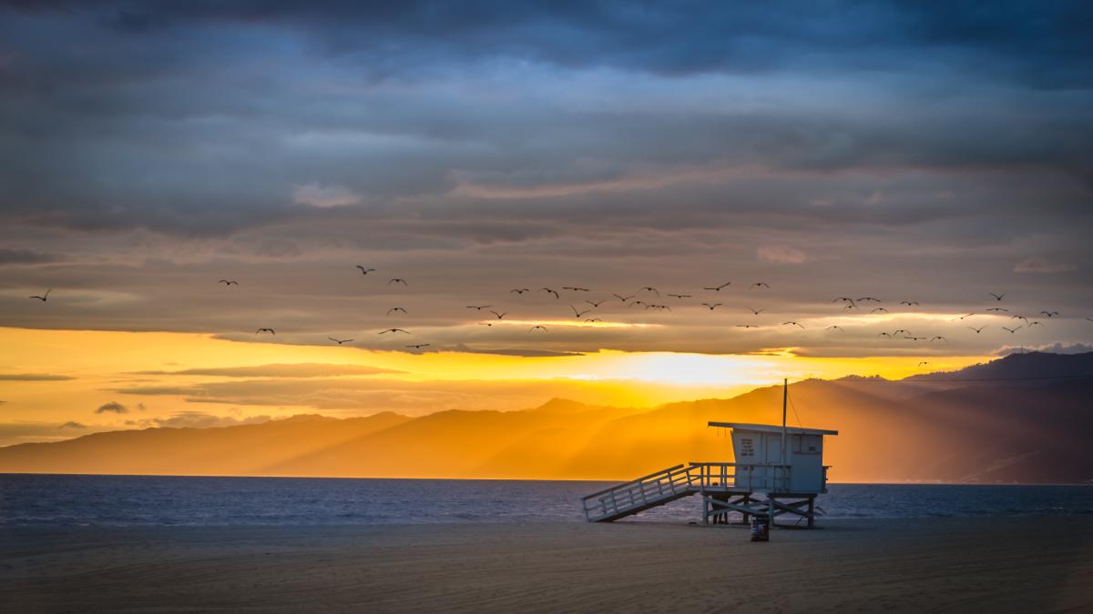 beautiful-shot-venice-beach-with-mountains-distance-cloudy-sky-sunset_63611100