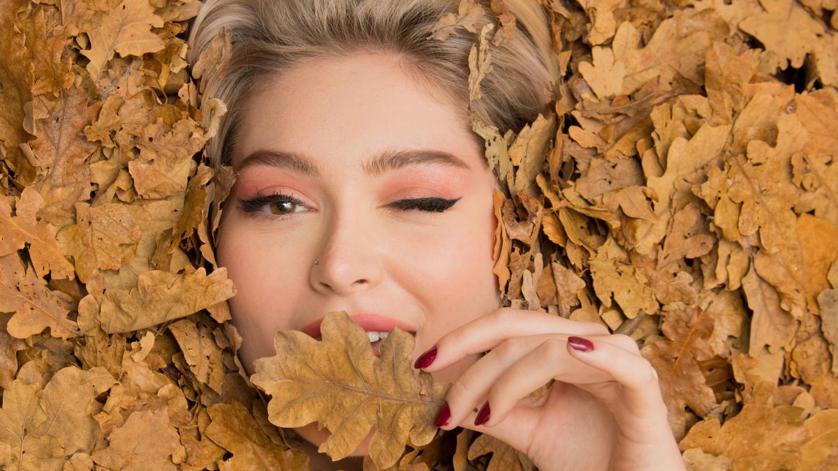 portrait-young-woman-amidst-autumn-leaves