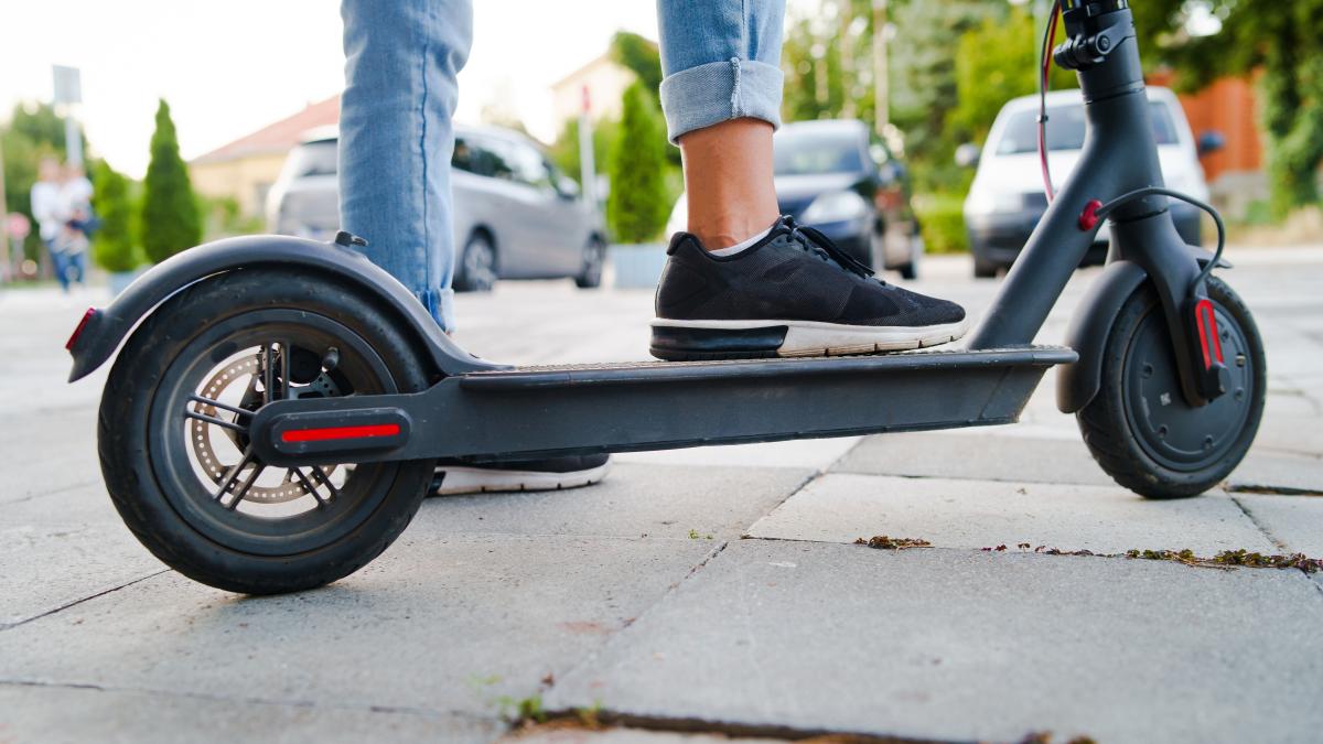 low-section-person-riding-push-scooter-road_40823500