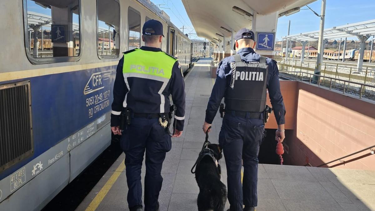 politisti cu spatele in gara uniforme politisti