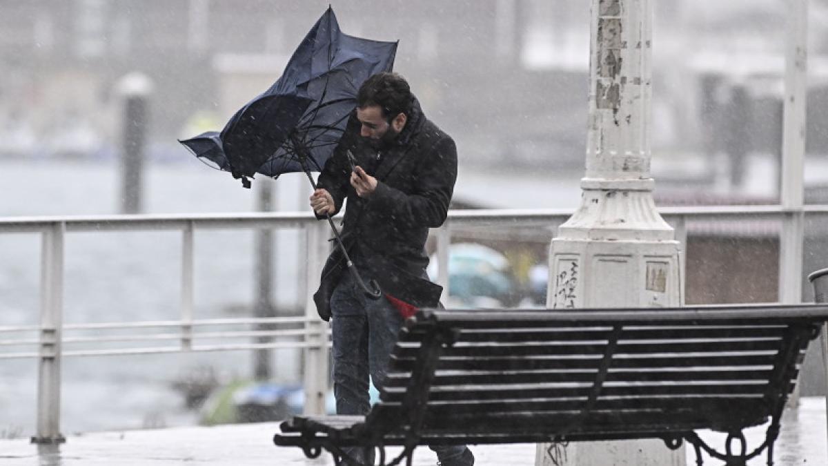 imagine cu un barbat cu o umbrela, furtuna