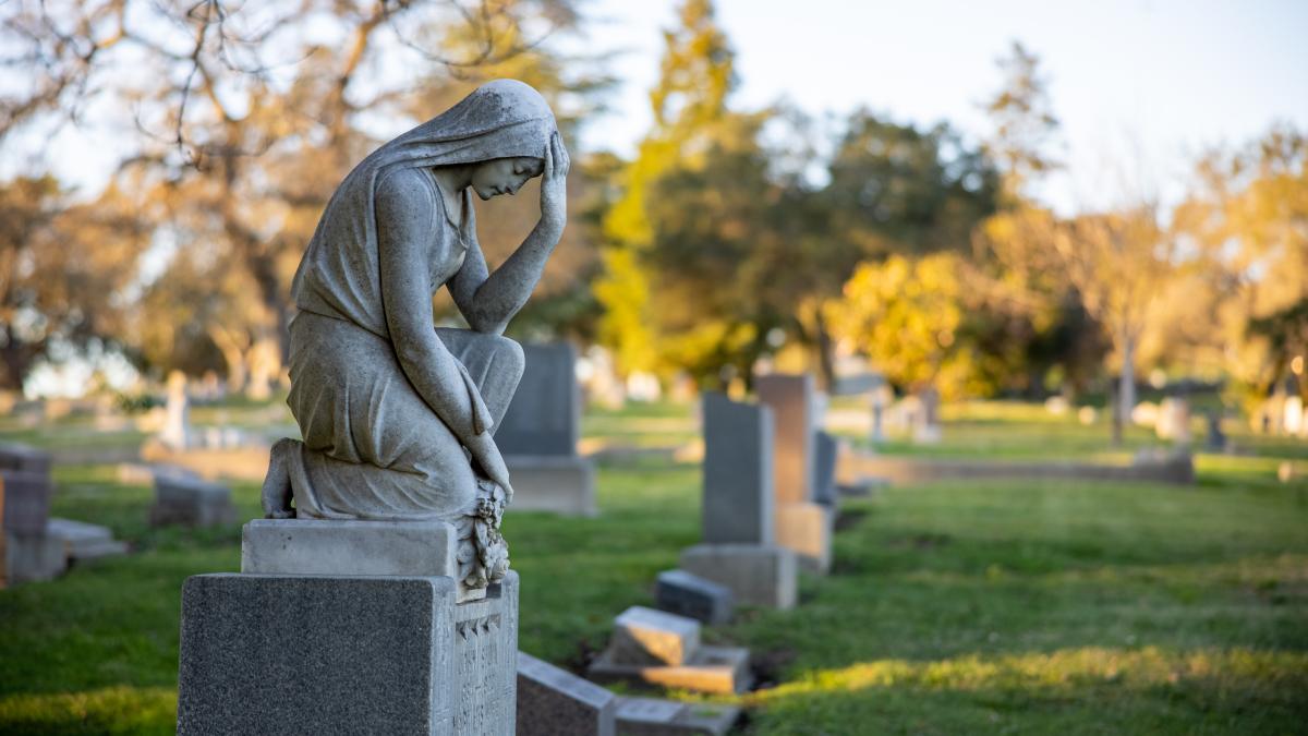 femeie rugaciune cimitir