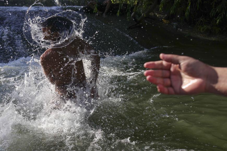 Imagini emoționante din România. Muncitori asiatici se răcoresc și se distrează alături de localnici, într-un râu din Ilfov / foto și video