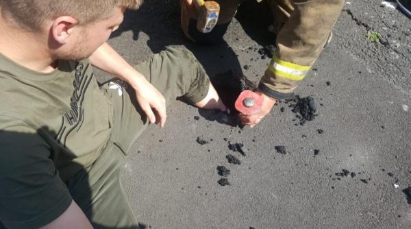 tanar blocat cu piciorul in asfaltul topit