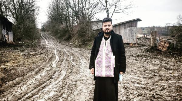 imaginea zilei preot care infrunta noroaiele pentru a binecuvanta crestinii de boboteaza