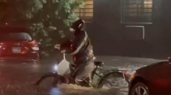 video viral cu un curier care a mers spre adresa de livrare chiar daca apa era aproape pana la brau