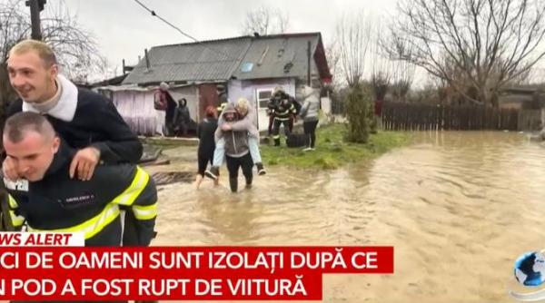 tineri carati de pompieri in spinare ca sa nu se ude pe papuci in apa de 10 centimetri foto
