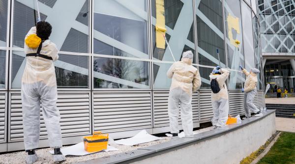 activisti greenpeace protest la sediul omv petrom mesajul scris cu vopsea galbena pe cladire foto