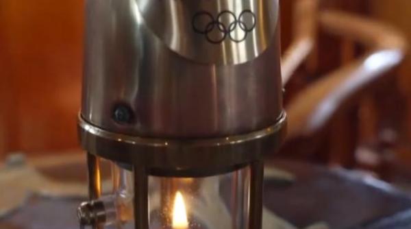 flacara olimpica escortata de garda de coasta italiana