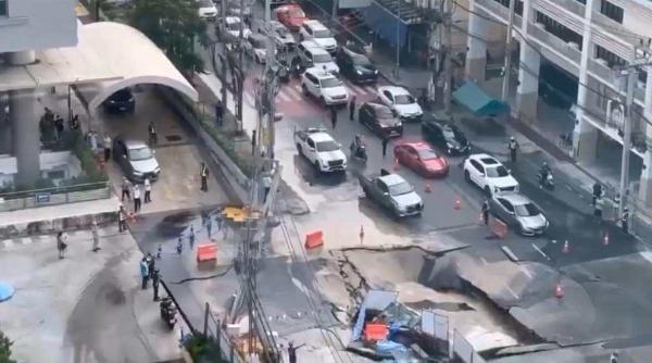 momentul in care un crater urias inghite masini si stalpi de electricitate in centrul unei capitale video